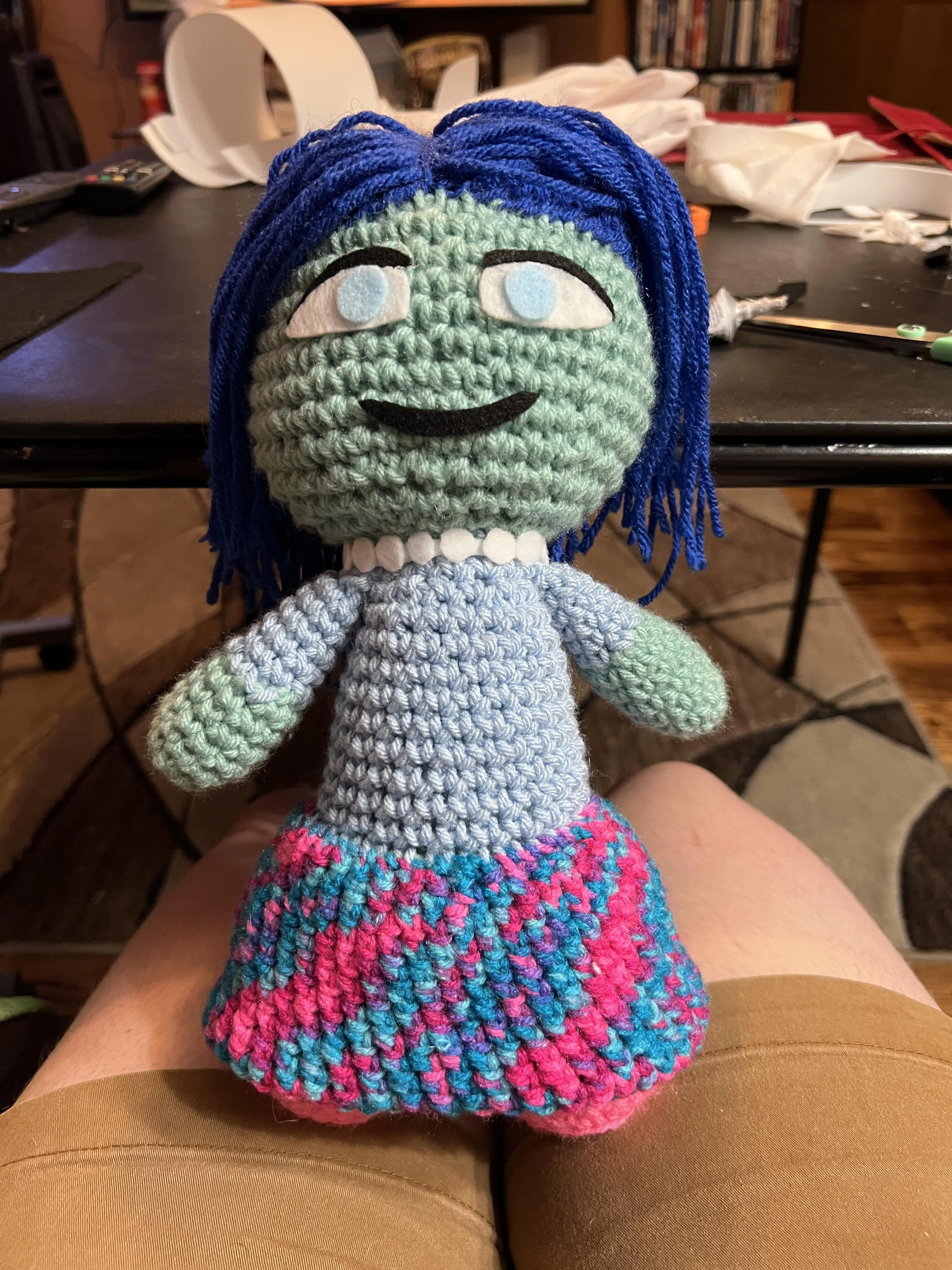 Blue skinned doll with dark blue hair and multicolored skirt